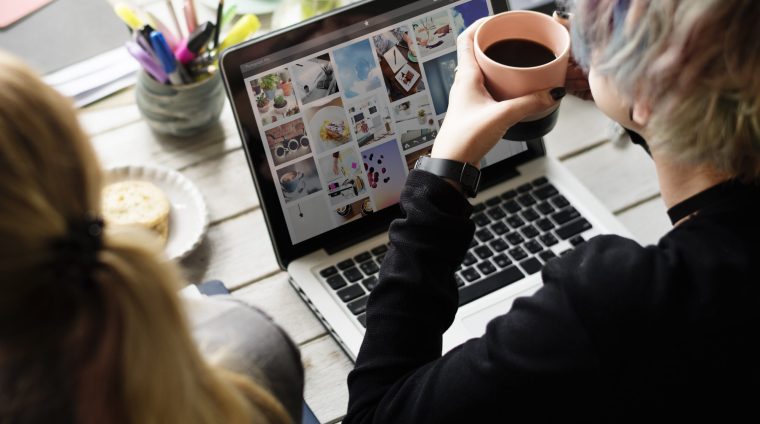 Woman Hands Holding Coffee Cup Working on Laptop